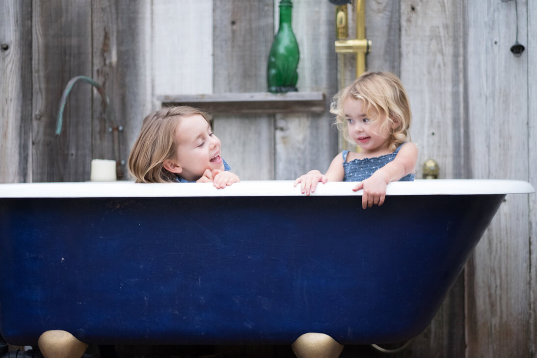 Sisters pose in bathtub for family photo