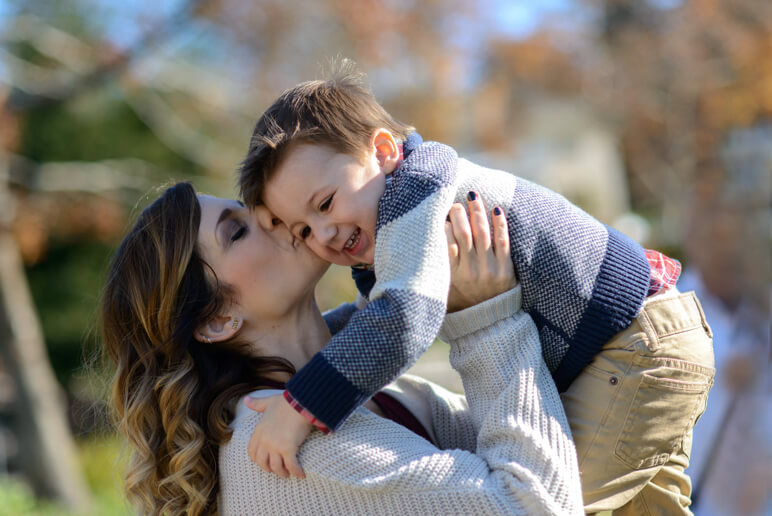 Mother kisses her son in adorable family photo